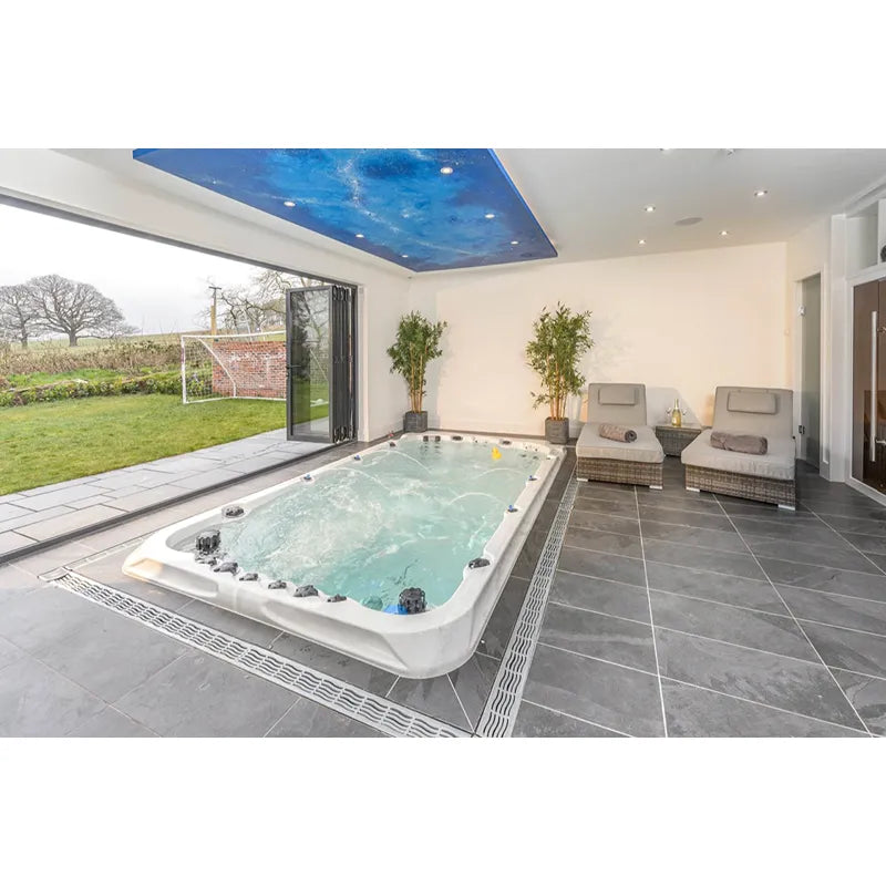 Passion Spas Activity 2 Swim Spa für 3 Personen in modernem Wellnessraum mit Gartenblich, Whirlpool mit türkisem Wasser