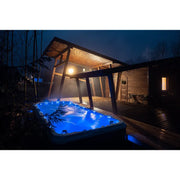 Passion Spas Activity 2 Swim Spa für 3 Personen bei Nacht mit LED-Beleuchtung im Garten