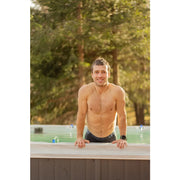 Mann in Passion Spas Activity 2 Swim Spa für 3 Personen, 549x226x126/152 cm, Garten mit Bäumen