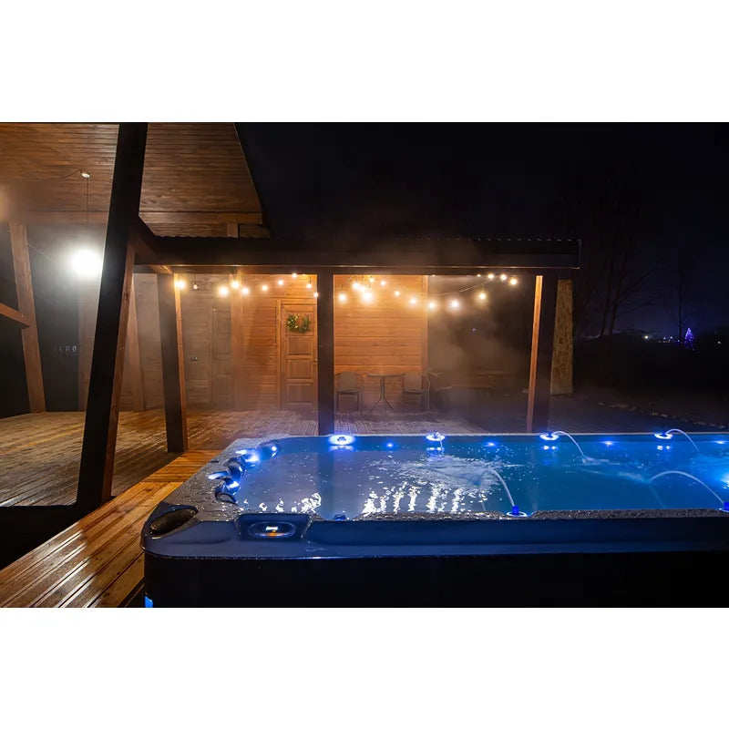 Passion Spas Activity 2 Swim Spa für 3 Personen mit LED-Beleuchtung in nächtlichem Gartensetting