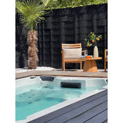 Passion Spas Aquatic 1 Eco Swim Spa für 3 Personen in modernem Garten mit Loungebereich und Palmengarten