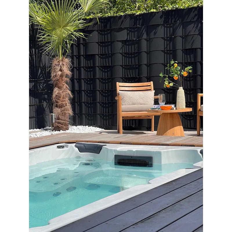Passion Spas Aquatic 1 Eco Swim Spa für 3 Personen in modernem Garten mit Loungebereich und Palmengarten