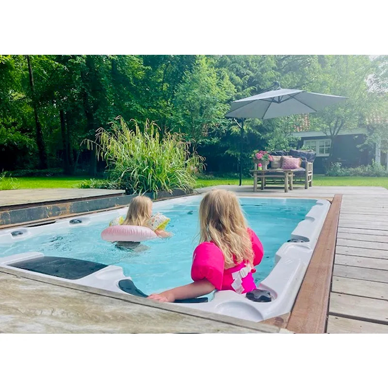 Passion Spas Aquatic 1 Swim Spa für 3 Personen mit zwei Kindern im Wasser, eingebaut im Garten