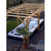 Passion Spas Aquatic 2 Swim Spa für 2 Personen mit Holzüberdachung im Garten, Person badet darin