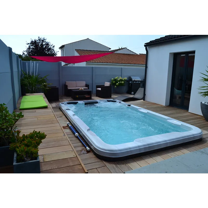 Passion Spas Aquatic 2 Swim Spa für 2 Personen in Gartenterrasse mit Holzdeck, blauem Wasser und Loungebereich