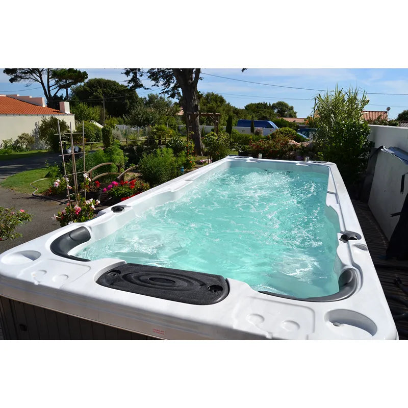 Passion Spas Aquatic 2 Swim Spa für 2 Personen im Garten mit türkisblauem Wasser und Massagedüsen