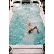 Passion Spas Aquatic 2 Swim Spa: Person schwimmt in weißem Swim Spa mit türkisblauem Wasser