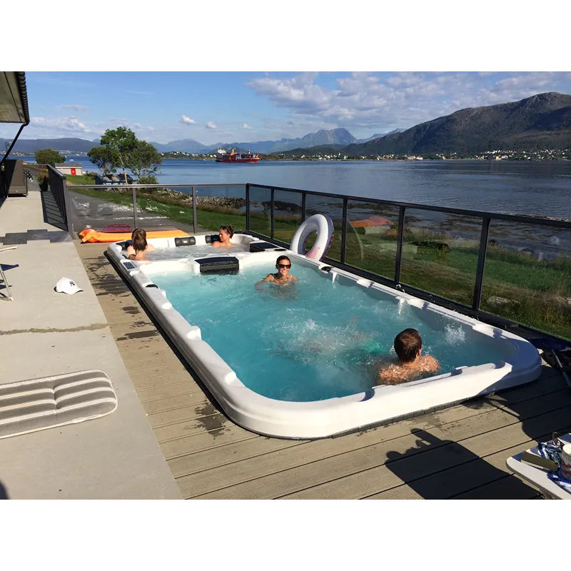 Passion Spas Aquatic 3 Deep Swim Spa für 8 Personen mit mehreren Personen in türkisblauem Wasser auf sonniger Terrasse mit Bergblick