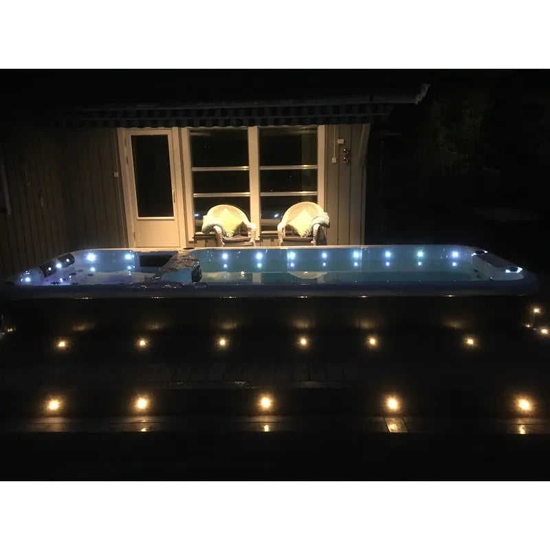 Passion Spas Aquatic 3 Swim Spa für 8 Personen nachts beleuchtet im Garten mit LED-Beleuchtung