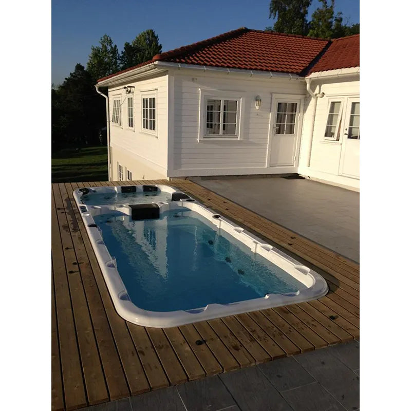 Passion Spas Aquatic 3 Swim Spa für 8 Personen auf Holzterrasse vor weißem Poolhaus