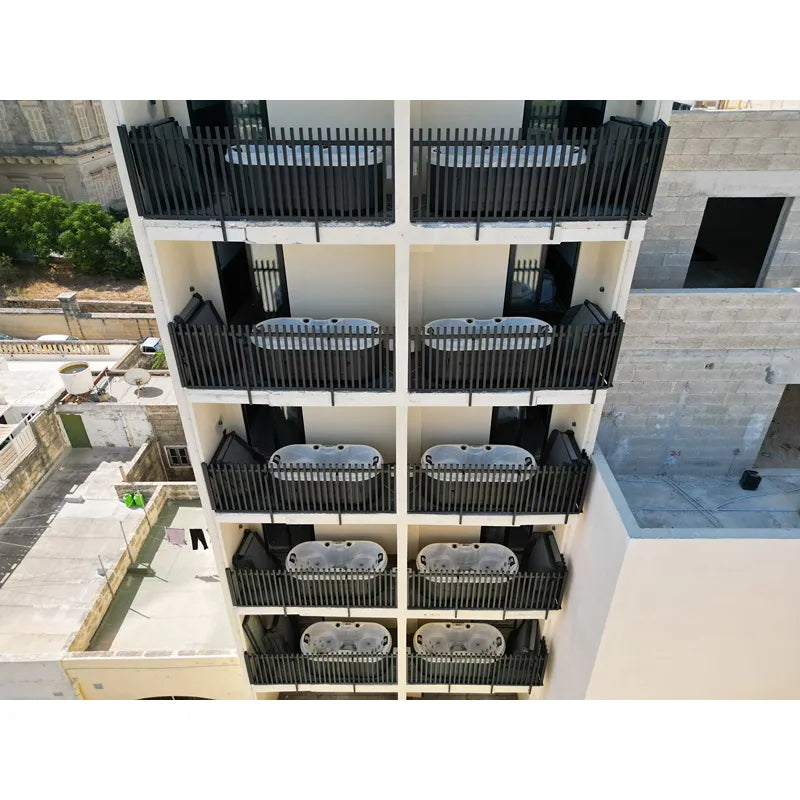 Mehrgeschossiges Wohngebäude mit zahlreichen Passion Spas Bliss Whirlpools auf den Balkonen, schwarze Geländer, cremefarbene Fassade