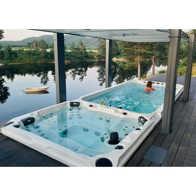 Passion Spas Dynamic Swim Spa im Außenbereich auf einer Terrasse mit Blick auf einen See – Kombination aus Schwimmzone und Whirlpool