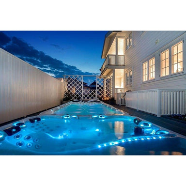 Passion Spas Energy Swim Spa im Außenbereich bei Nacht mit LED-Beleuchtung, Massagebereich und Schwimmzone