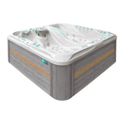 Passion Spas Euphoria Mighty Wave Whirlpool für 4 Personen mit weißem Kunststoffbecken, graues Holzumrandung und Kontrollpaneelen auf der Seite