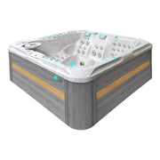 Passion Spas Exhilarate Whirlpool mit grauem Holzrahmen und goldenen Akzenten, weißem Innenbecken, 132 Düsen und türkisfarbenen Bedienfeldern für 6 Personen