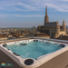  Passion Spas Happy Whirlpool in Betrieb auf einer Dachterrasse mit Blick auf den Stephansdom in Wien – mit Wasserbefüllung und stimmungsvoller LED-Beleuchtung.