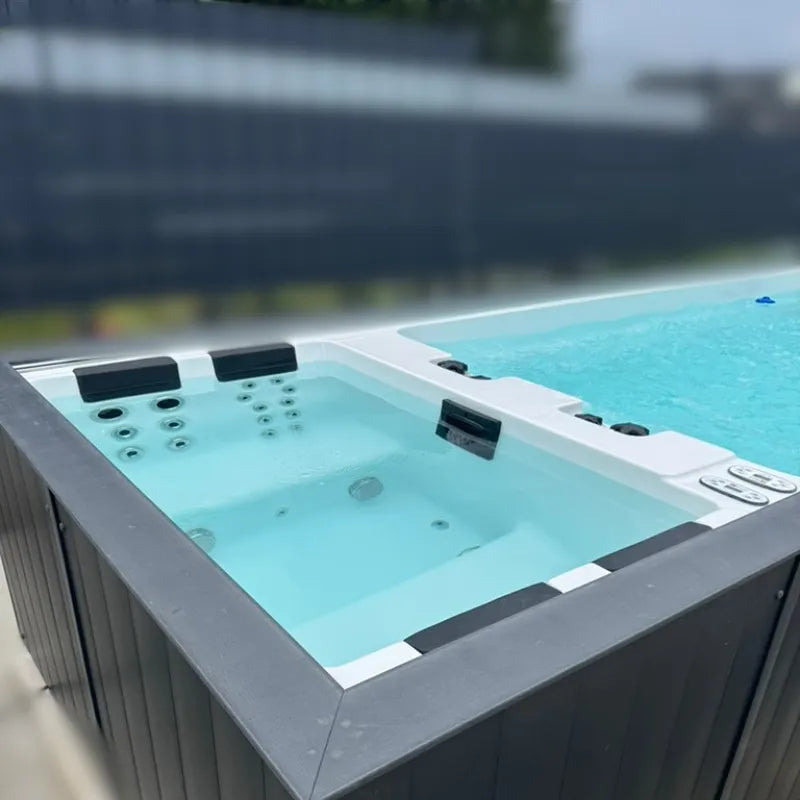 Passion Spas Whirlpool Balance 600x228x138 cm - 4 Personen mit türkisblauem Wasser und Bedienungselementen im Garten