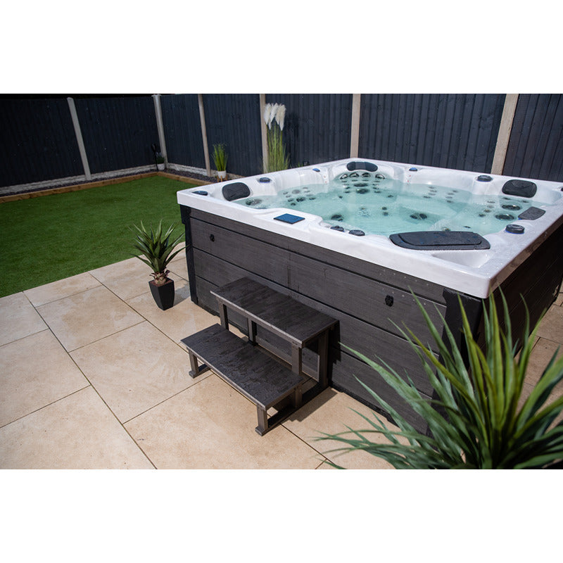 Platinum Spas Onyx Sterling Silver Whirlpool auf eleganter Gartenterrasse mit Pflanzen und Einstiegstreppe