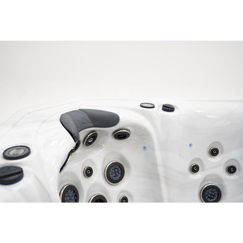 Detailaufnahme eines weißen Whirlpools mit ergonomischem Kopfkissen, mehreren Massagendüsen und Luftauslässen
