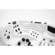 Draufsicht auf den Platinum Spas Barcelona Whirlpool mit weißem Kunststoffbecken, zahlreichen schwarzen Massagendüsen und Wasserstrahlen für Premium-Entspannung.