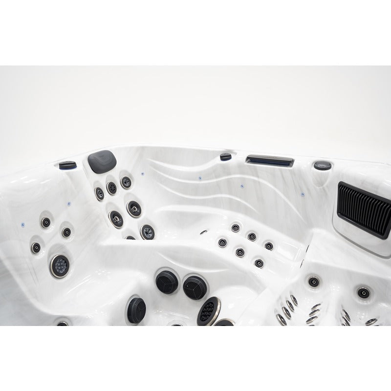 Draufsicht auf den Platinum Spas Barcelona Whirlpool mit weißem Kunststoffbecken, zahlreichen schwarzen Massagendüsen und Wasserstrahlen für Premium-Entspannung.