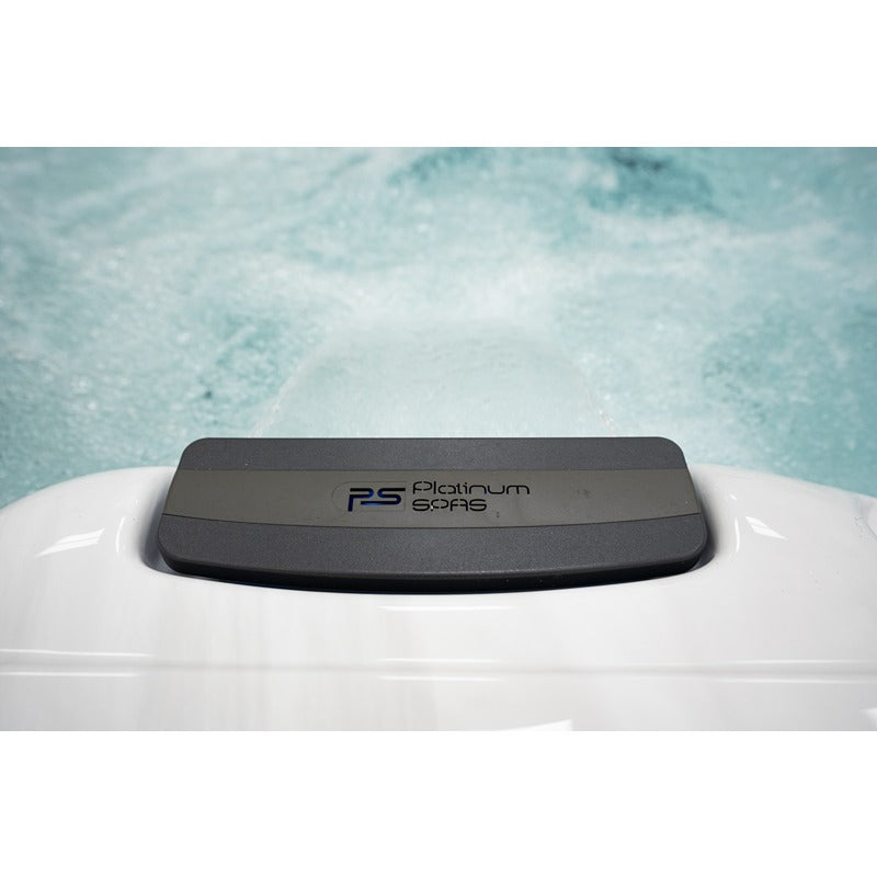 Platinum Spas Barcelona Whirlpool mit schwarzem Kopfkissen an der Badewannenkante, dahinter sprudelndes türkisfarbenes Wasser