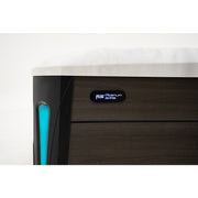 Detailaufnahme der Platinum Spas Barcelona Whirlpool-Ecke mit dunkelbrauner Holzoptik und blauem Griffelement, Typenschild sichtbar