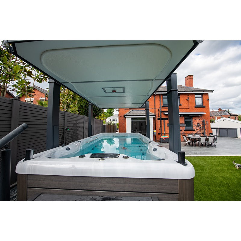 Outdoor-Installation des Platinum Spas Eros Swim Spa unter Überdachung im modernen Garten eines Einfamilienhauses