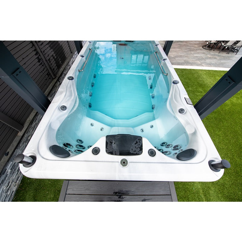 Vorderansicht des Platinum Spas Eros Swim Spa mit befülltem Becken, ergonomischer Sitzfläche und integrierten Massagedüsen im Außenbereich
