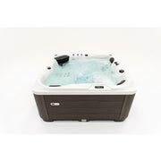  Platinum Spas Happy Whirlpool mit aktivierten Massagedüsen und Wasserfontänen – Frontansicht im Betrieb
