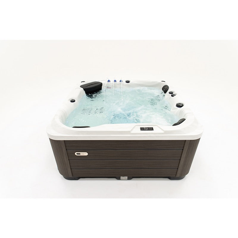  Platinum Spas Happy Whirlpool mit aktivierten Massagedüsen und Wasserfontänen – Frontansicht im Betrieb