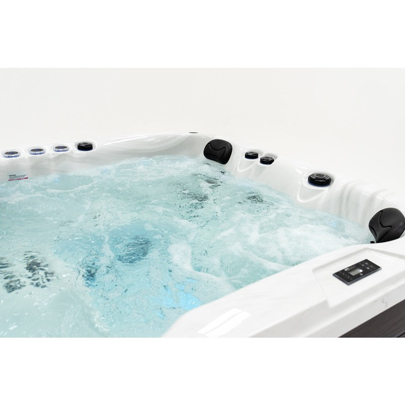 Platinum Spas Happy Outdoor Whirlpool mit sprudelndem türkisblauem Wasser, weißem Kunststoffgehäuse, schwarzen Düsen und Kontrollpanel für bis zu 5 Personen.