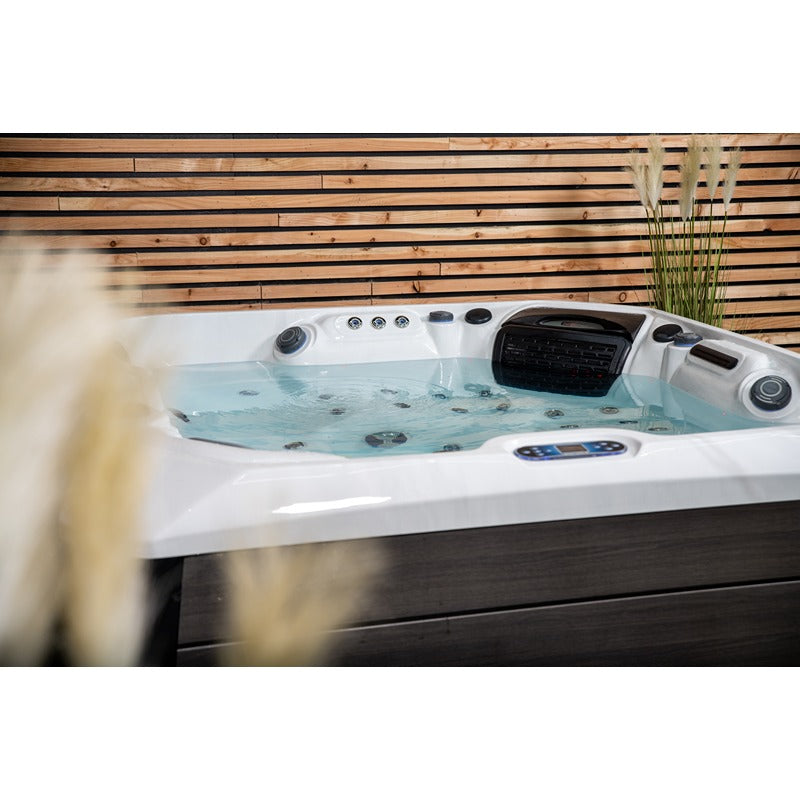Nahaufnahme des befüllten Platinum Spas Kenya Hot Tubs mit sichtbaren Massagedüsen, Wasserstand und intuitivem Balboa-Bedienfeld – stilvolle Verbindung aus Technik und Ästhetik.