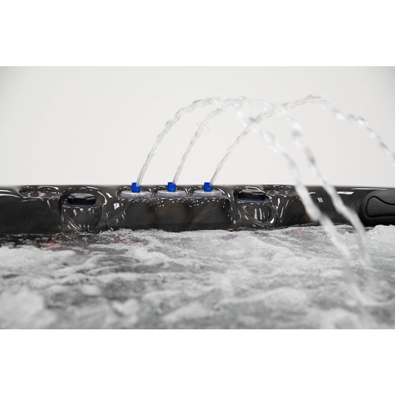 Platinum Spas Seville Whirlpool – vier gleichmäßige Wasserfontänen sprudeln über den Beckenrand bei laufendem Betrieb