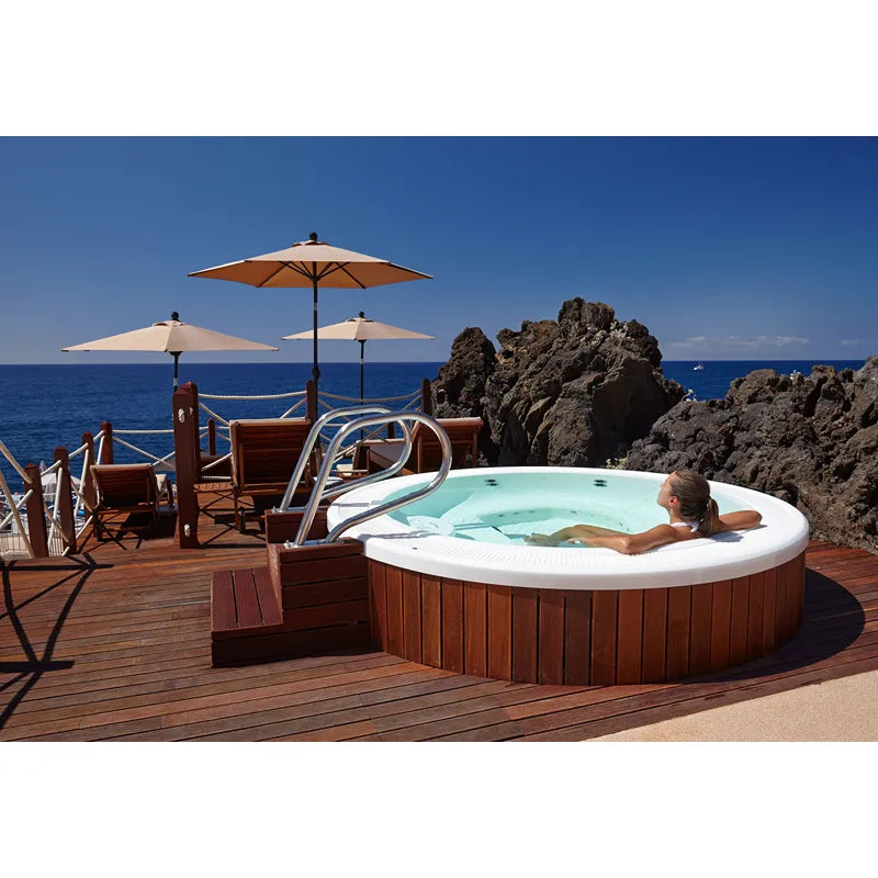 Portcril Club 25 Overflow Spa 7-Personen Whirlpool mit Überlaufwasserfall auf Holzterrasse mit Meerblick