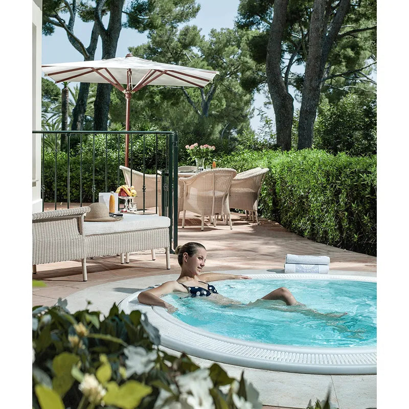 Portcril Club 25 Overflow Spa 7-Personen Whirlpool in Gartenanlage mit Frau beim Entspannen