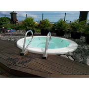 Portcril Club 28 Overflow Spa 9-Personen Whirlpool mit türkisblauem Wasser und Einstiegsleitern auf Holzterrasse