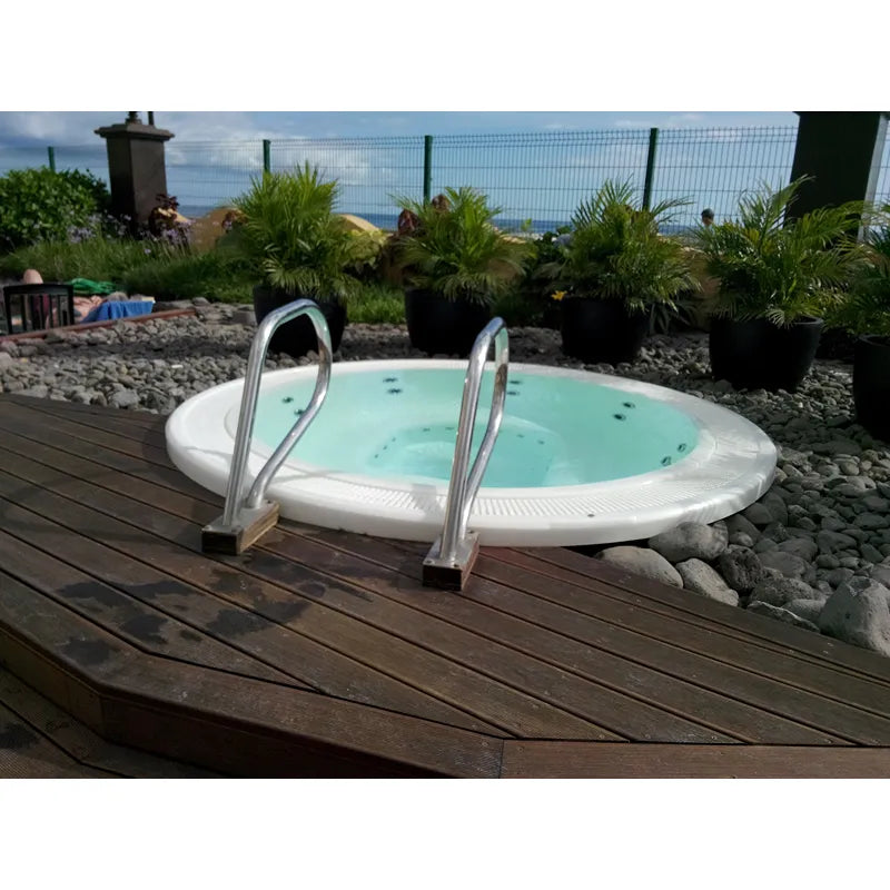 Portcril Club 28 Overflow Spa 9-Personen Whirlpool mit türkisblauem Wasser und Einstiegsleitern auf Holzterrasse