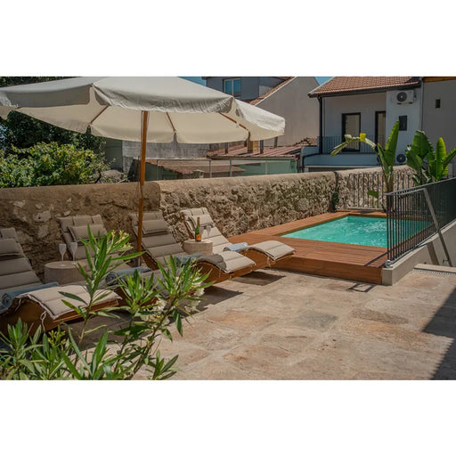 Portcril Diva Swim 42 großer Swim Spa mit Düsen in modernem Poolbereich mit Holzdeck und Loungebereich