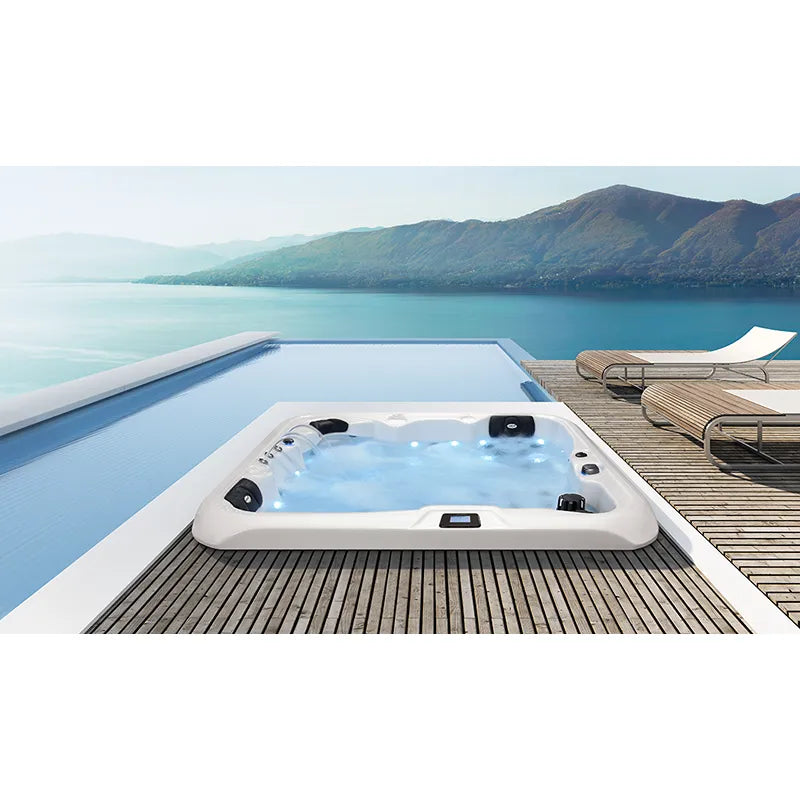 Portcril Double 520 Spa Premium Whirlpool mit weißem Rahmen und schwarzen Düsen am Holzdeck mit Seeblick