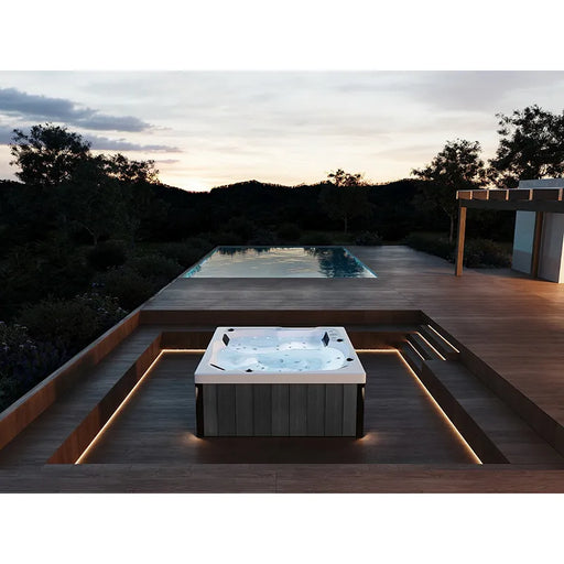 Portcril Emotion 3 Spa 3-Personen Whirlpool mit LED-Beleuchtung auf Holzterrasse im Garten bei Dämmerung