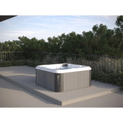 Portcril Essential 4 Spa 4-Personen Whirlpool mit weißem Rand auf sonniger Terrasse mit Gartenbäumen