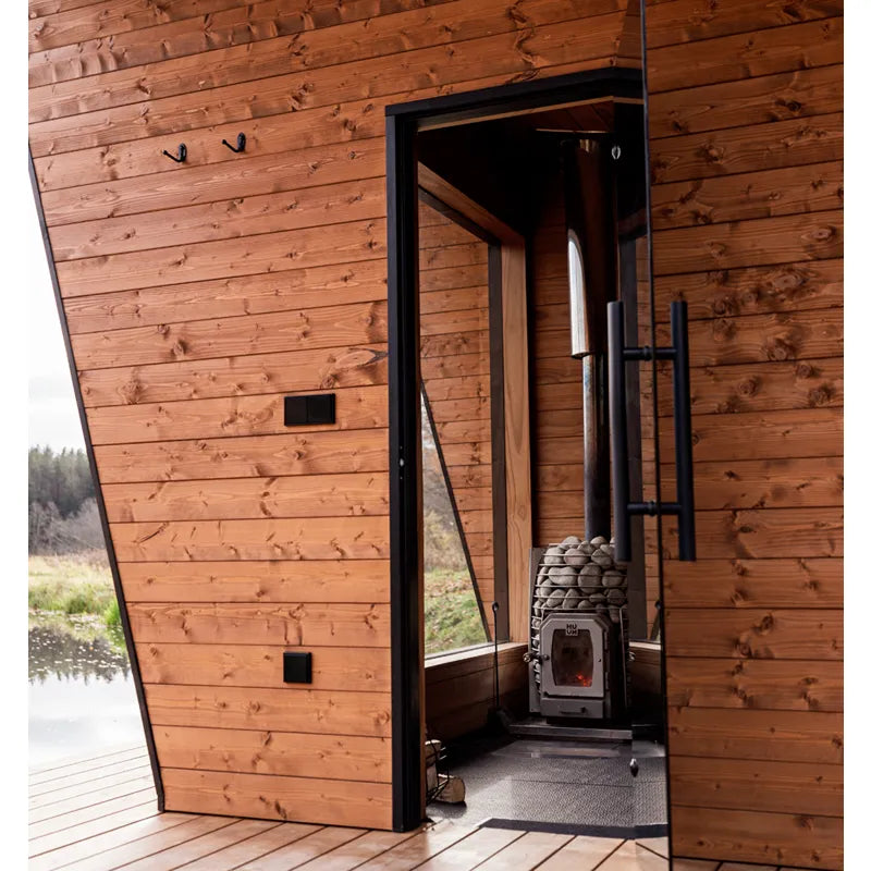 HUUM Sauna Huum Hive Wood Holzsaunaofen mit schwarzem Rahmen in moderner Gartensauna aus Holz, Innen- & Außenbefeuerung sichtbar