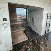 Tyrol Innensauna - Alpenländisches Design von Savne Štrus mit Holzbänken, Glastür und Marmor-Innenausstattung