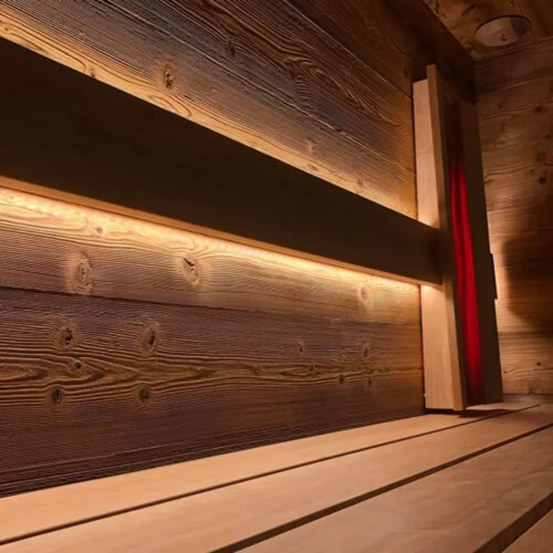Savne Štrus Tyrol Innensauna - Alpenländisches Design mit beleuchteten Holzbänken und dunklem Holzpaneel im Innenraum