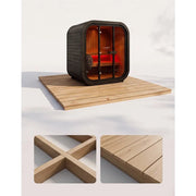 Swedish Cold Grand Escape Gartensauna 4 Personen 90°C mit schwarzem Außengehäuse und orangeholz-Innenraum auf Holzplattform