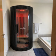Swedish Cold Sanctuary Solo Infrarot-Innensauna 1 Person mit schwarzem Gehäuse und rotem Infrarotlicht im modernen Badezimmer