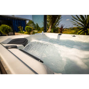 Detailansicht des Topaz Whirlpools mit Wasserfallfunktion und sprudelndem Wasser – luxuriöses Spa-Erlebnis im Garten.
