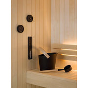 Tylö Brilliant Sauna-Set Eimer & Kelle Schwarz in schwarzer Ausführung auf Saunabank, mit Saunathermometer und Aufgussstein