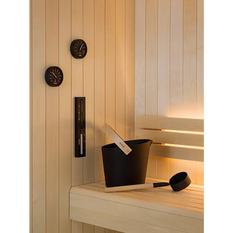 Tylö Brilliant Sauna-Set Eimer & Kelle Schwarz in schwarzer Ausführung auf Saunabank, mit Saunathermometer und Aufgussstein